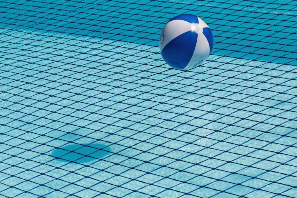 Wasserball, der aufs Wasserf im Pool fällt