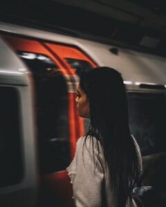 Frau steht an vorbeifahrender U-Bahn